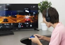 Adolescente menino online joga um jogo de computador com fones de ouvido e um joystick, console de jogo