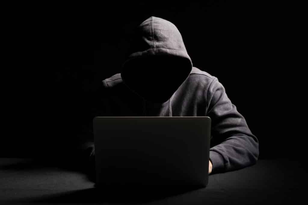 Hacker trabalhando em laptop no escuro 