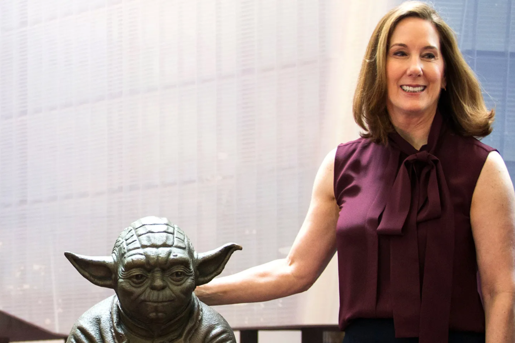 Kathleen Kennedy ao lado de um boneco do Mestre Yoda.