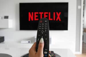 Mulher assistindo séries da netflix que foram canceladas