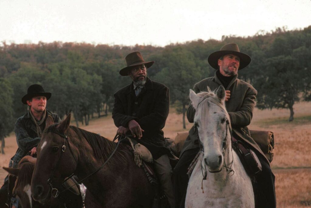 Clint Eastwood, Morgan Freeman e Jaimz Woolvett em cena de Os Imperdoáveis. Distribuição: Warner Bros.