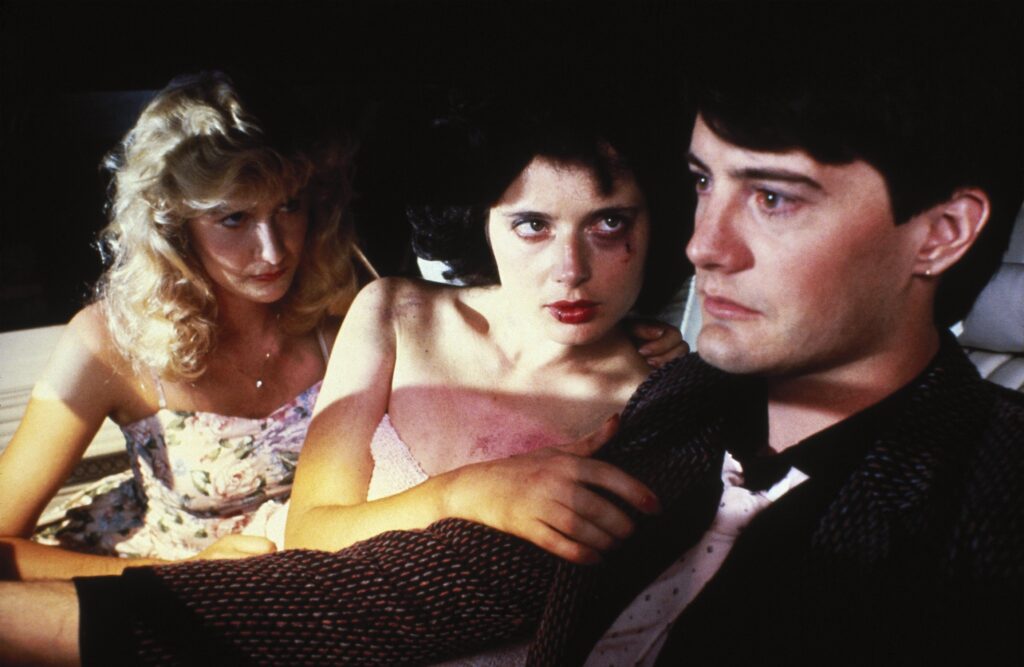 Kyle MacLachlan, Isabella Rossellini e Laura Dern em cena de Veludo Azul (1986). Distribuição: De Laurentiis Entertainment Group.