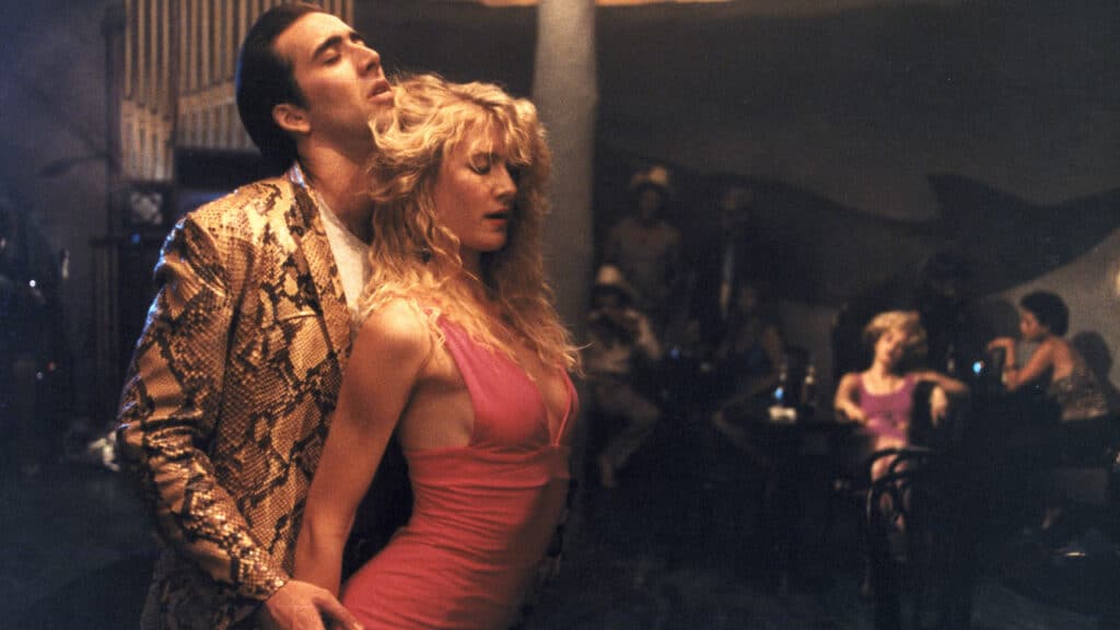 Nicolas Cage e Laura Dern em cena de Coração Selvagem (1990). Distribuição: The Samuel Goldwyn Company.